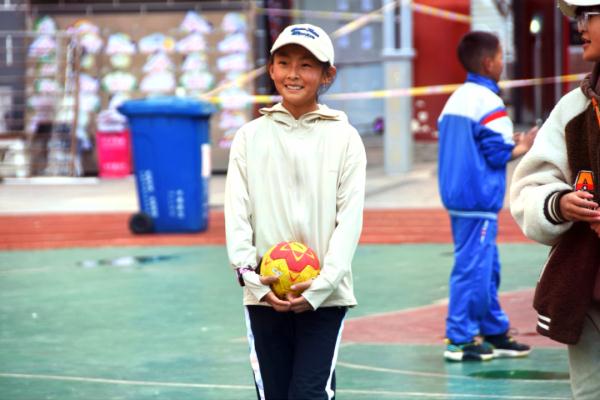 在高原上教孩子們打手球，“慢慢兒來，甭著急！”