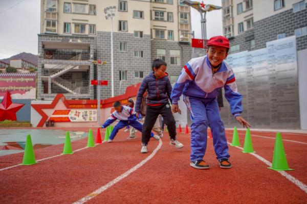 在高原上教孩子們打手球，“慢慢兒來，甭著急！”