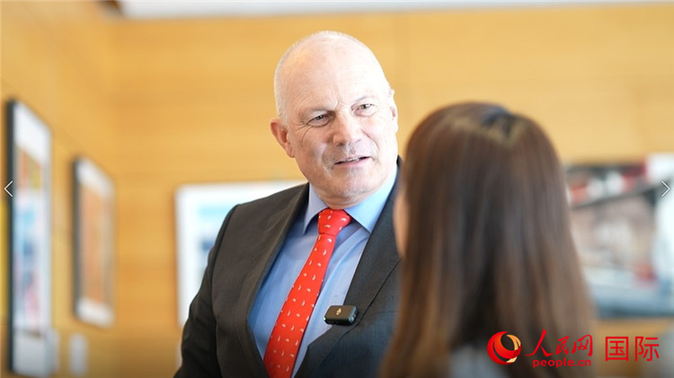 瑞士駐華大使白瑞誼介紹使館內(nèi)陳列的照片。人民網(wǎng) 彭昱凱攝