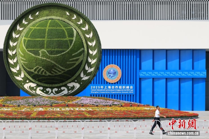 8月31日，天津，一名工作人員從2025年上海合作組織峰會主會場外的景觀花壇旁經(jīng)過。當日，2025年上海合作組織峰會在天津舉行。<a target='_blank' href='/'><p  align=