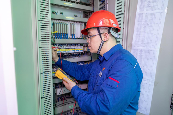 呂曉勇在保護盤柜前檢查二次回路接線情況。受訪者供圖
