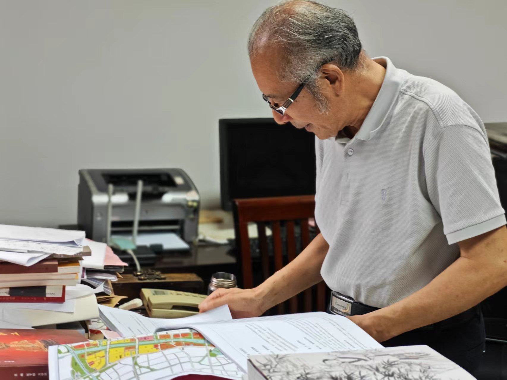 顧風在辦公室翻閱資料。人民網(wǎng)記者 黃鈺攝