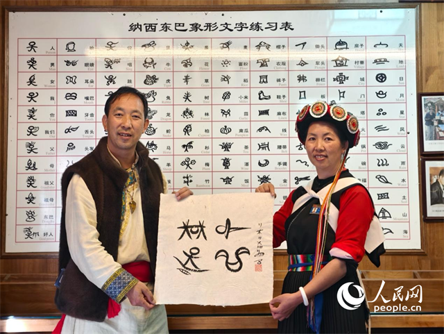 人民網(wǎng)“行進中國”云南調(diào)研采訪團走進麗江，和閏元現(xiàn)場用東巴文寫下“行進中國”。人民網(wǎng)記者 符皓攝