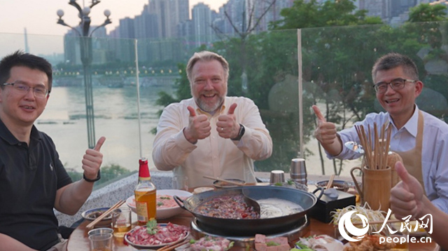 康寧顯示科技事業(yè)部全球拓建項目總監(jiān)軻寶華（中）和同事在重慶南濱路吃火鍋。人民網(wǎng)記者 蘇纓翔攝