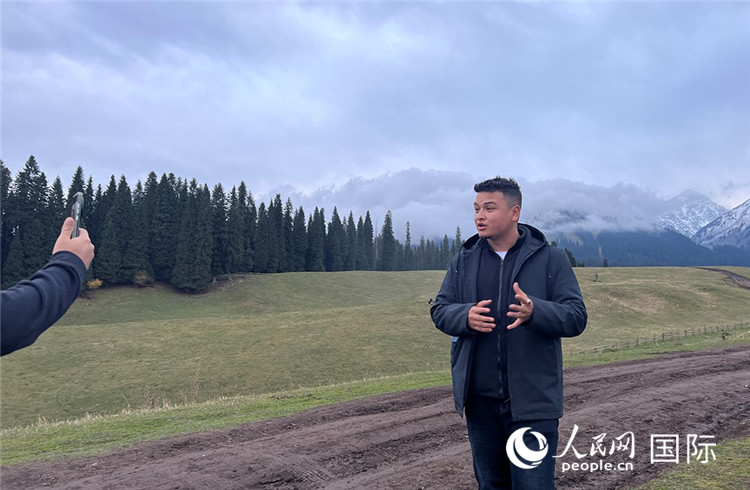 在庫爾德寧，吾買爾江被雪山美景震撼，即興錄制了短視頻作品。人民網(wǎng)記者曾書柔攝