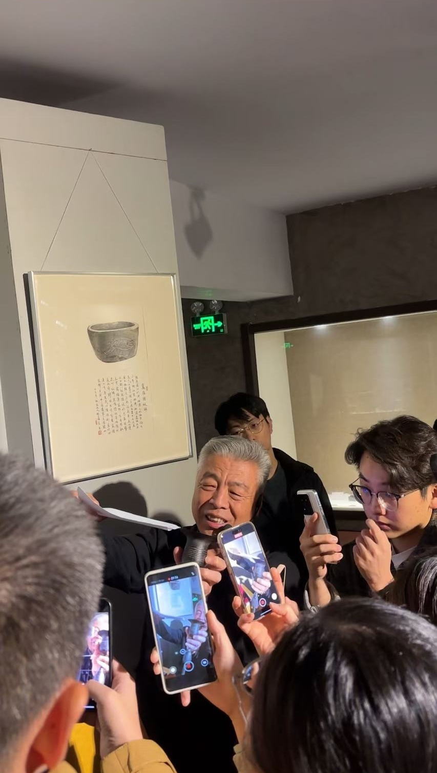 黑陶邢文化博物館館長邢葆東展示兩張相疊的A4紙，向記者解釋此為杯口的厚度。