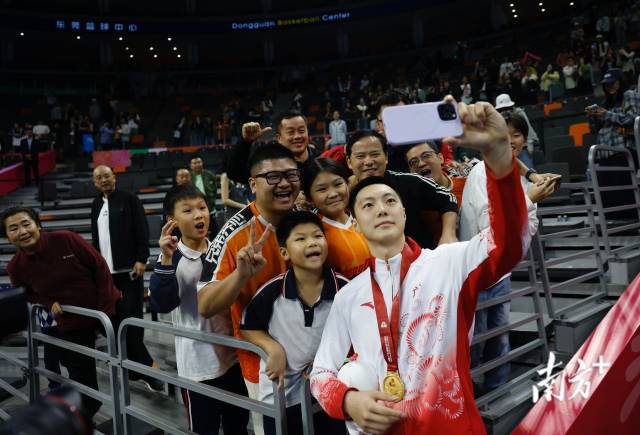 11月12日，十五運會男籃成年組決賽，廣東隊獲得冠軍后，胡明軒與球迷們合影留念。張由瓊 攝