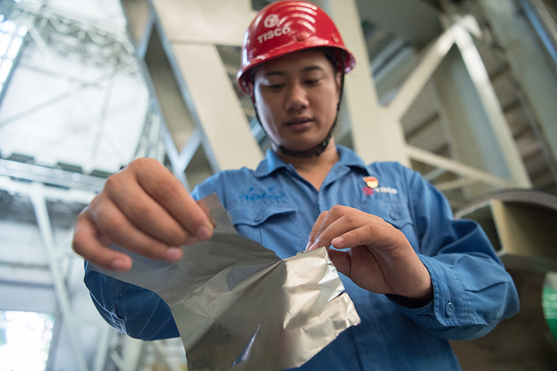 2018年8月8日，山西省太原市，太鋼精密帶鋼公司工作人員用手撕開不銹鋼。