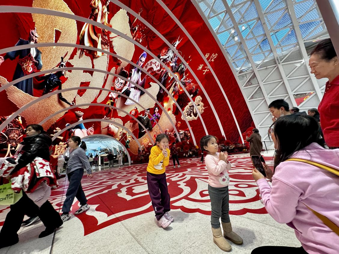 乙巳蛇年春節(jié)期間，影迷在《哪吒之魔童鬧海》巨幅海報前拍照打卡。