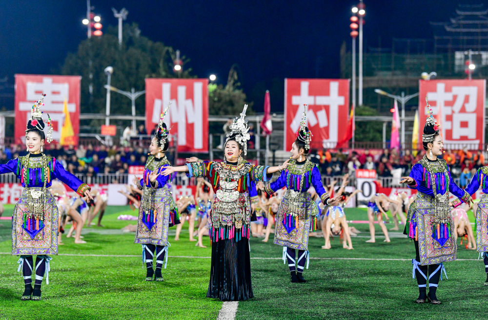 2025年3月14日，2025年貴州“村超”40強交叉賽在榕江“村超”足球場舉行，演員在比賽間隙表演侗族大歌，民族文化伴隨著體育賽事成功“出圈”。圖片來源：新華社