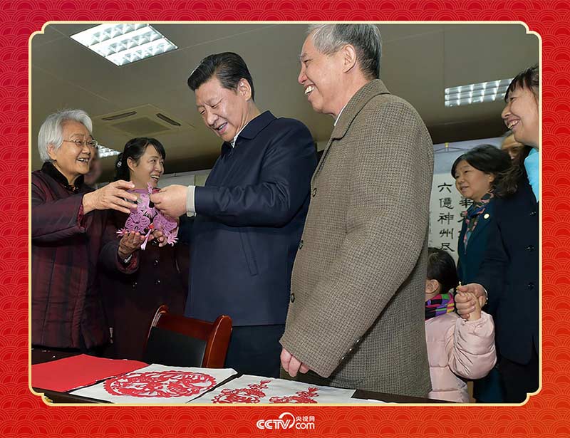 2015年2月15日，習近平在西安市雁塔區(qū)電子城街道二〇五所社區(qū)服務中心欣賞社區(qū)居民的剪紙作品。