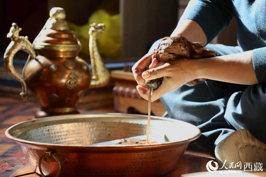 牛角鉆孔，將木泥擠出。人民網(wǎng)記者 次仁羅布攝