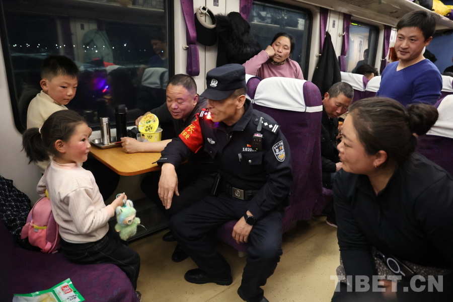 乘警長左紅彬在巡視車廂間隙，向攜帶兒童的旅客專門叮囑安全注意事項(xiàng)。.JPG