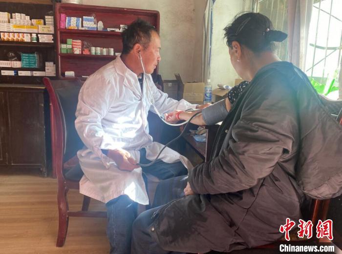 索木滾(左)為村民看病?！∪捞量h委宣傳部供圖