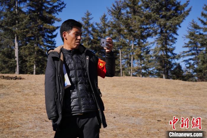 圖為桑杰加進(jìn)行巡查并拍照記錄?！●R銘言 攝