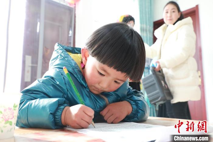 孩子們?cè)诩议T口上學(xué)，是楊周馬草搬入蘭州新家最為開心的事情。小女兒楊洋正在學(xué)習(xí)寫數(shù)字。　魏建軍 攝