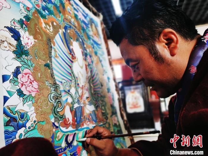 圖為久美尖措創(chuàng)作唐卡?！?zhí)砀?攝