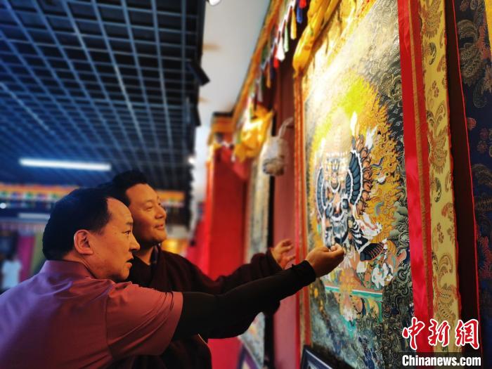 圖為久美尖措展示唐卡作品。　張?zhí)砀?攝