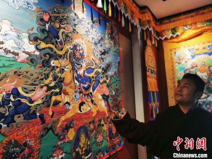 圖為久美尖措展示唐卡作品。　張?zhí)砀?攝
