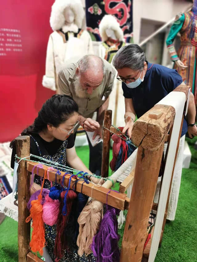 楊永良的學(xué)生在展會上向客商介紹加牙藏毯編織技藝。受訪者供圖