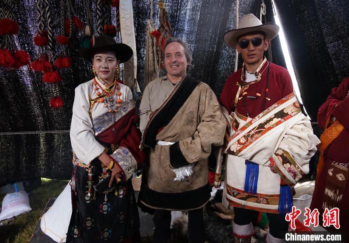 圖為一名外籍?dāng)z影師(中)身穿藏服和藏族民眾合影留念?！●R銘言 攝