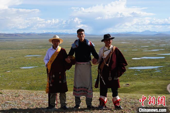 圖為一名留學(xué)生身穿自己國(guó)家的服飾和藏族民眾合影留念?！●R銘言 攝