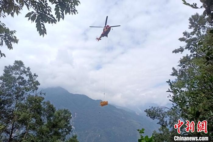 直升機起飛將搶修塔材運往海拔1950米的110千伏唐下線29號塔位?！⌒鞈c明 攝
