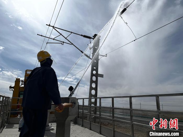 圖為高壓水槍的水柱沖洗絕緣子串。　高啟宏 攝