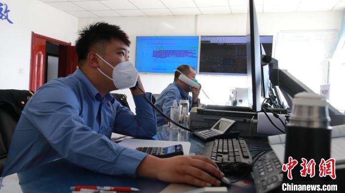 圖為貨運調(diào)度人員與外勤工作人員聯(lián)系掌握車輛裝載情況?！±钌?攝