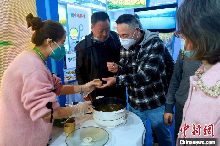 圖為杭州市民品嘗茶卡羊肉?！±铍h 攝