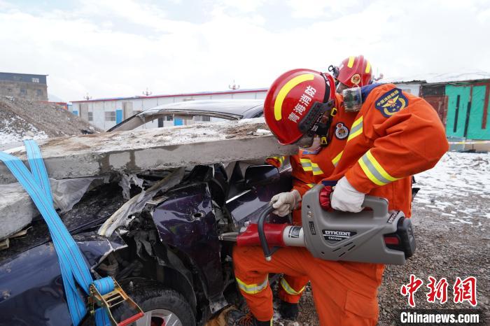 圖為地震實戰(zhàn)拉動現(xiàn)場，參演人員進行車輛破拆。　玉樹消防供圖