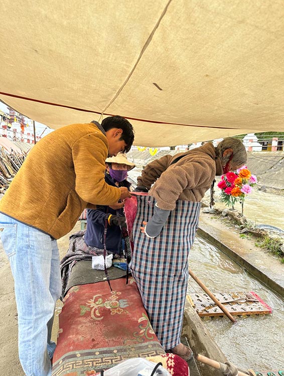 扎西奪爾登為路邊老人送去保暖圍腰。阿壩州文明辦供圖