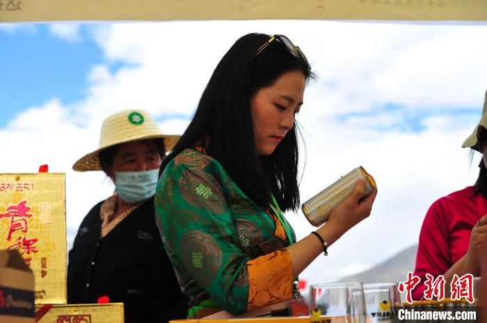 圖為拉薩市民在特色農(nóng)畜產(chǎn)品展示展銷會上選購商品。　張偉 攝