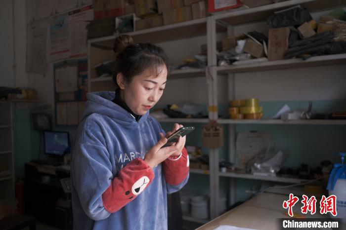 正在快遞站點(diǎn)內(nèi)忙碌的楊莉春。　何蓬磊 攝