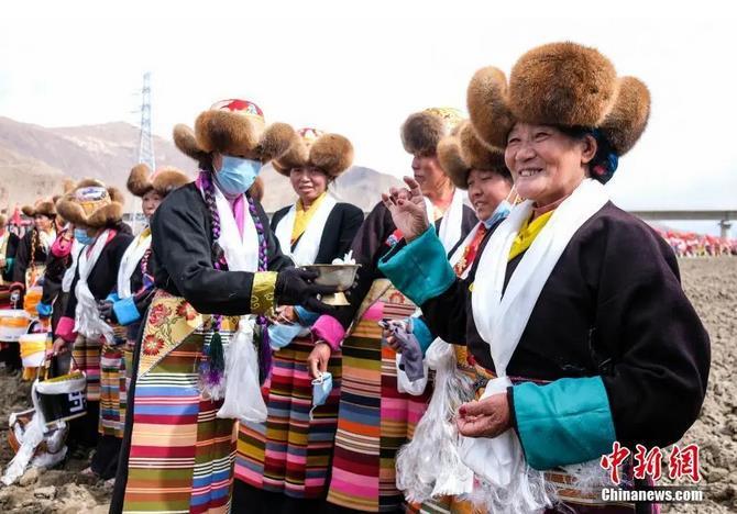 資料圖：西藏自治區(qū)拉薩市曲水縣才納鄉(xiāng)協(xié)榮村參加春耕儀式的村民互敬青稞酒。按照傳統(tǒng)，當(dāng)?shù)卮迕裆碇?jié)日盛裝，舉行隆重的儀式，祈福一年的豐收。<a target='_blank' ><p  align=