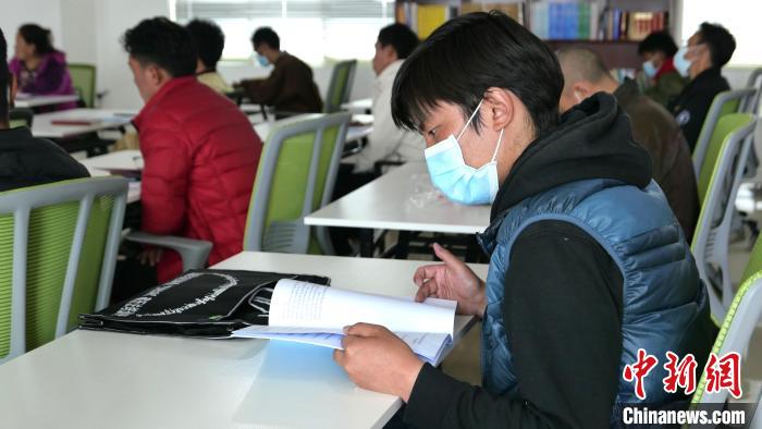 圖為正在閱讀“杰松達(dá)孜”藏歷法教材的學(xué)員。　謝牧 攝