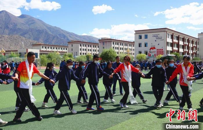 圖為世界冠軍與拉薩阿里地區(qū)高級(jí)中學(xué)學(xué)生一起跳鍋莊。　冉文娟 攝