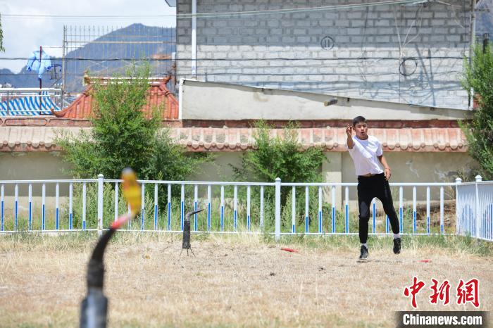 圖為西藏自治區(qū)拉薩市賽馬場(chǎng)內(nèi)市民在體驗(yàn)“打牛角”項(xiàng)目?！∝暩聛?lái)松 攝