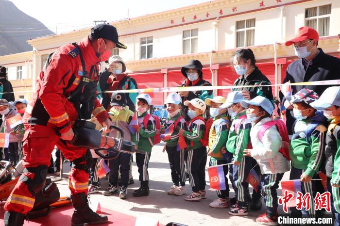 圖為消防指戰(zhàn)員為學生講解、演示先進救援裝備?！≮w琳 攝