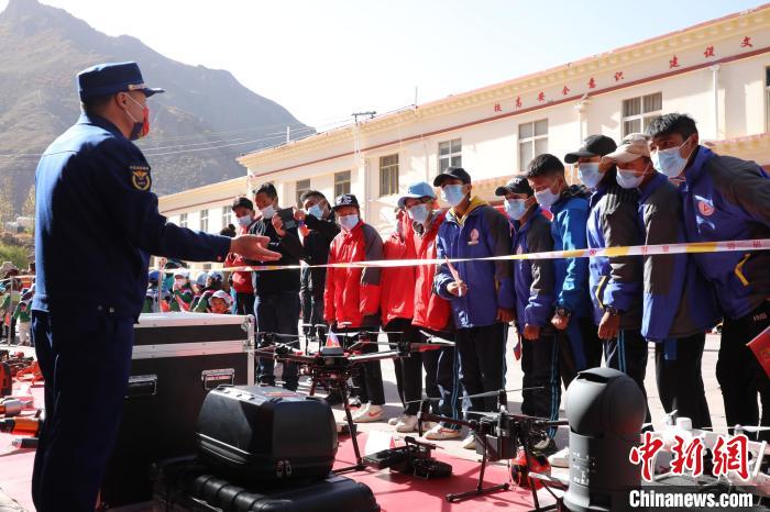 圖為消防指戰(zhàn)員為學生講解、演示先進救援裝備?！≮w琳 攝