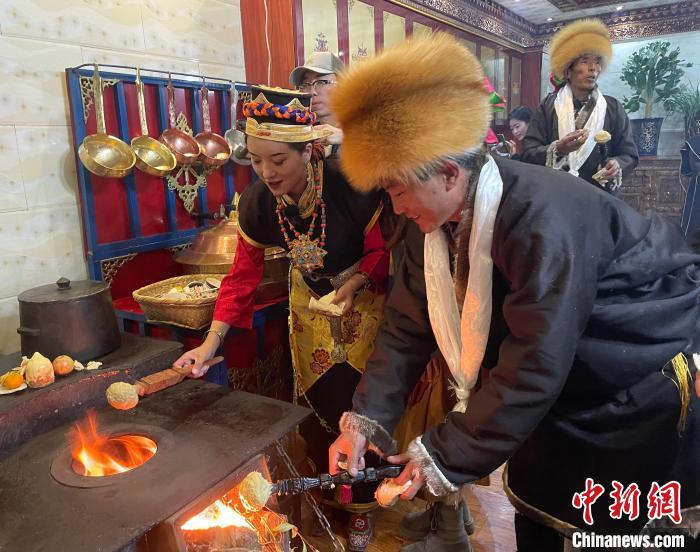 圖為人們?cè)诨鹕峡竟?jié)日美食“結(jié)達(dá)”。　冉文娟 攝