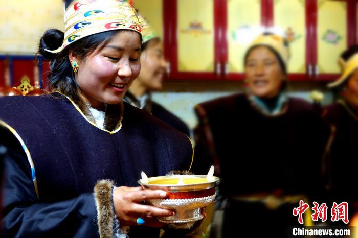 圖為藏族姑娘向客人敬酒?！∪轿木?攝