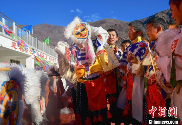 圖為加查縣安繞鎮(zhèn)小學學生在試穿藏戲面具?！∝暩聛硭?攝