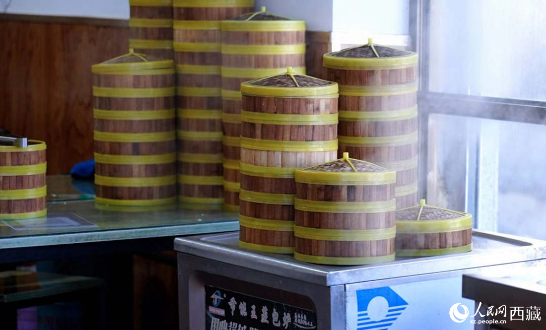 電蒸箱上擺滿了多屜熱氣騰騰的包子。人民網(wǎng) 次仁羅布攝