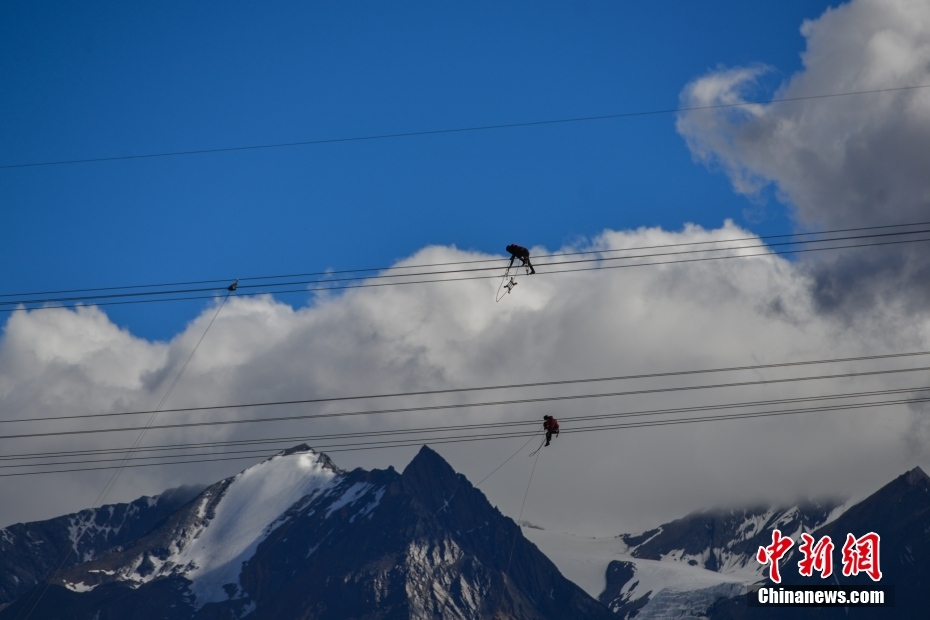 資料圖為2020年6月23日，西藏阿里聯(lián)網(wǎng)工程施工人員在日喀則希夏邦馬雪山附近進行走線作業(yè)，安裝絕緣設(shè)備。 <a target='_blank' href='/'><p  align=
