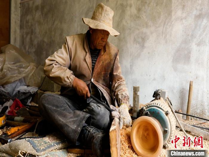 圖為手工藝人正在制作木碗?！?鄧海平 攝