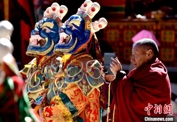 2月19日，正在拍攝跳神活動的僧人?！±盍?攝