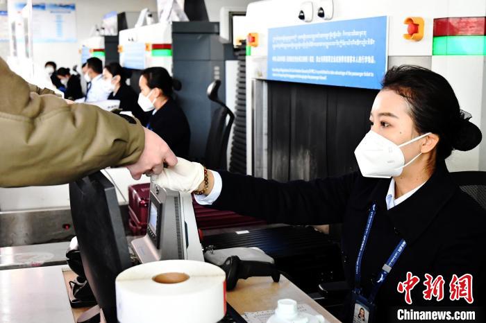 圖為機(jī)場工作人員為旅客辦理行李托運(yùn)?！≈芎?攝