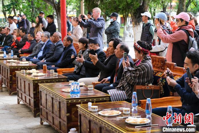 5月19日，中外嘉賓在羅布林卡和游客一起觀看藏戲?！〗w波 攝