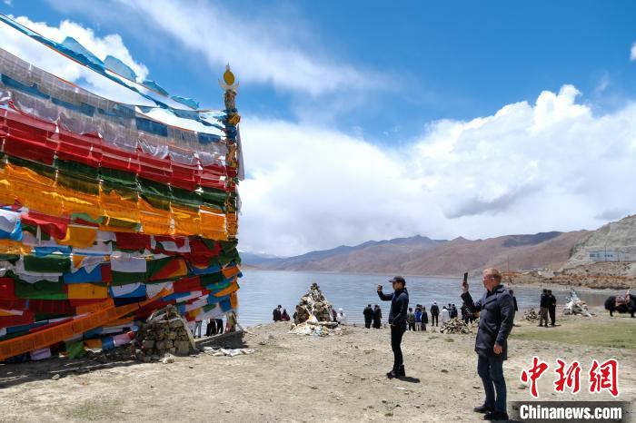 進藏參訪嘉賓在羊湖畔拍攝經(jīng)幡?！〗w波 攝
